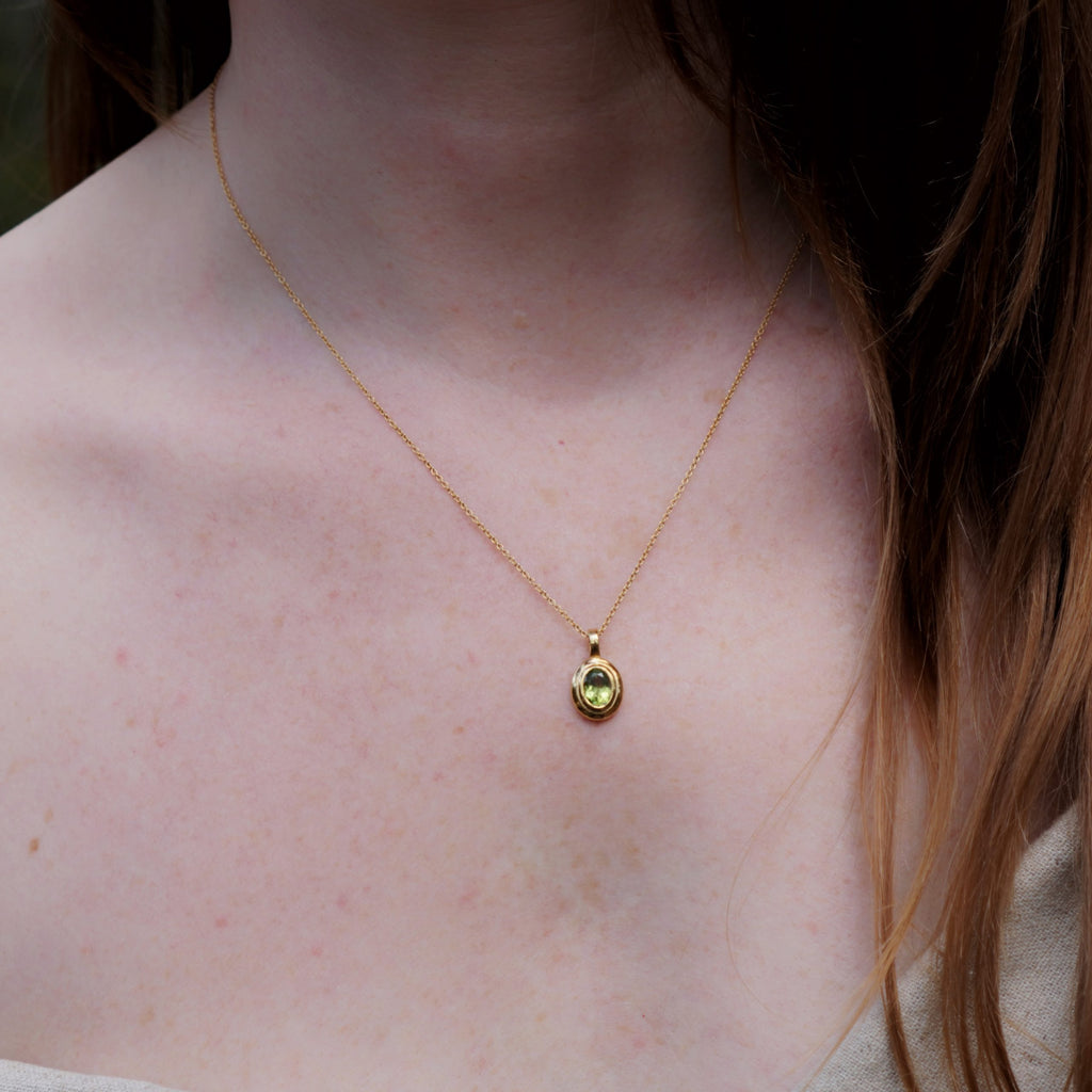 Peridot birthstone pendant necklace in brass, August gemstone jewellery on model