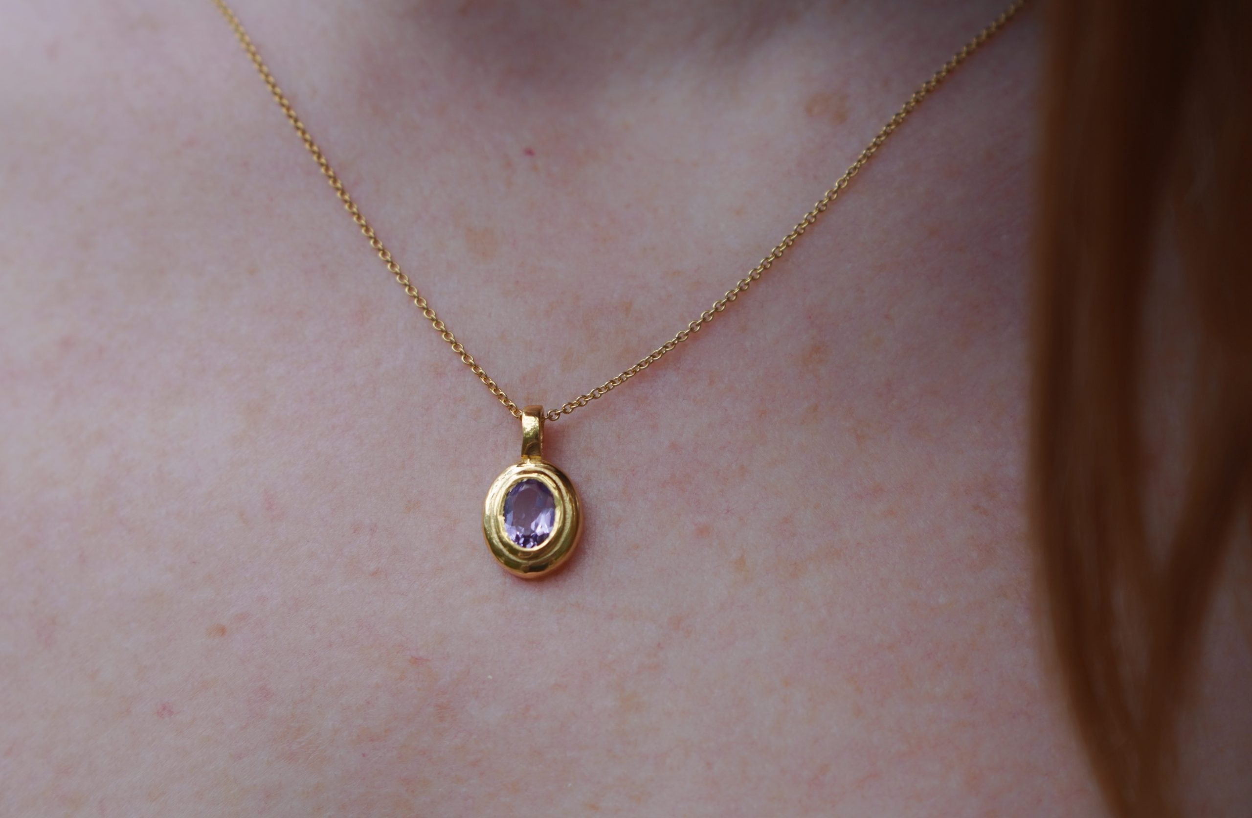 Close-up of the deep purple Amethyst stone and hand-finished golden brass setting