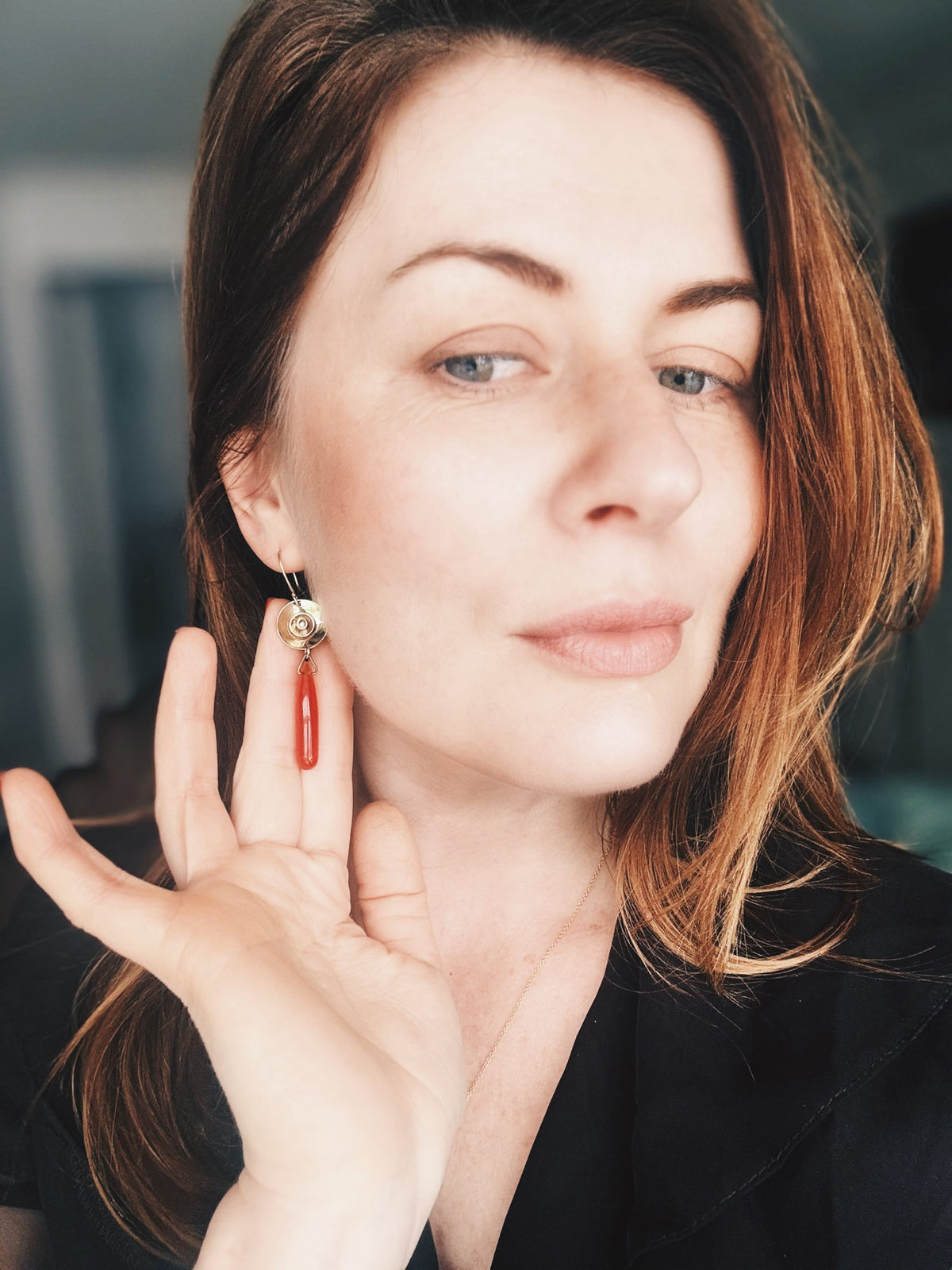 Me holding the Carnelian earrings in my palm to show the actual scale and weight